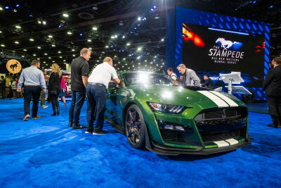  Spectators look over a Shelby Cobra on display in Ford's booth at the Detroit Auto Show Sept. 14. 