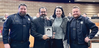   Sterling Heights Broadcast Services Coordinator Dan Rizek, second from left, received a national Hometown Media Award in the Audio Programming-Access Center Professional category for the “Talk’n the Beat” podcast. The award was shared with Sterling Heights police officers Kevin Coates, far left, and Larry Reynolds, far right, from the Community Services Bureau, for their role in hosting the podcast. Also pictured is Sterling Heights Community Relations Director Melanie Davis. 