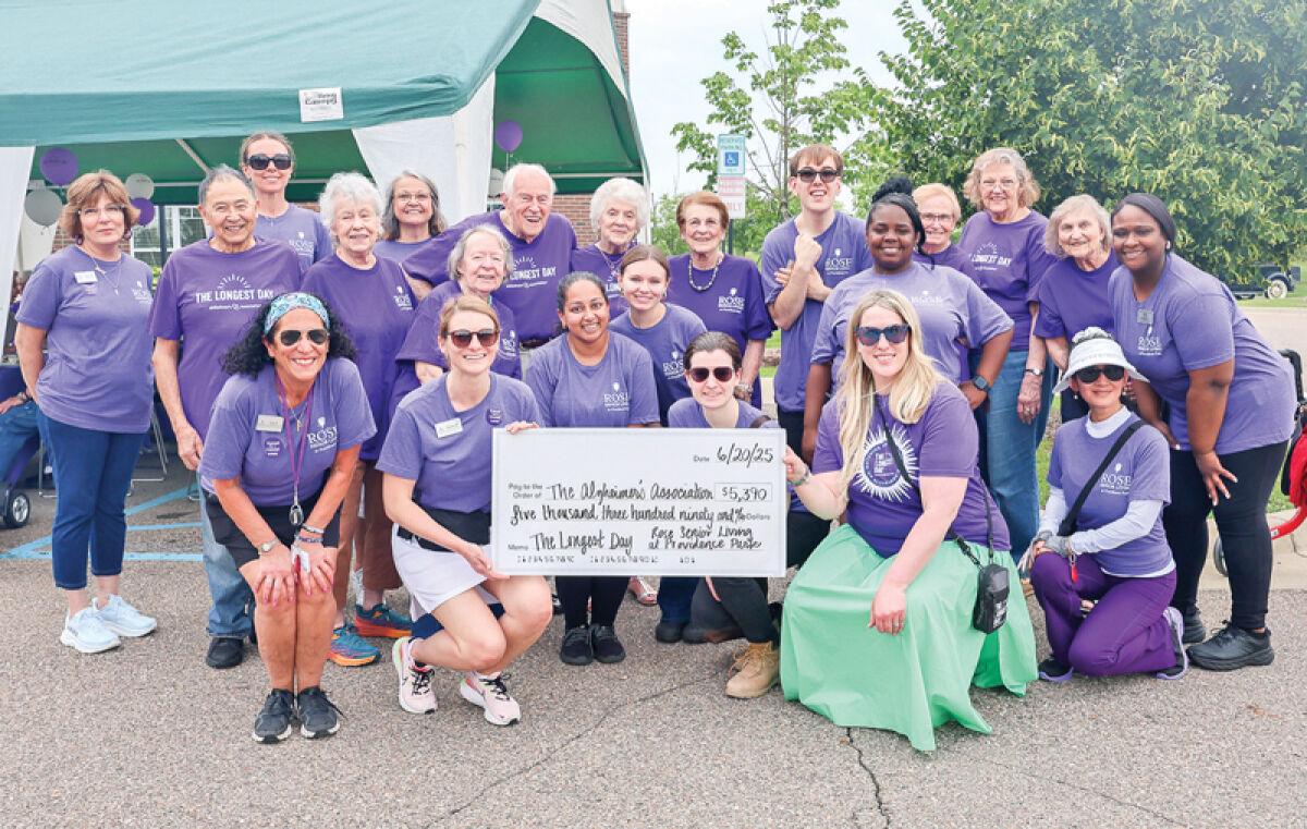  Rose Senior Living staff pose for a picture after presenting Kathleen Sable, of the Alzheimer’s Association, with a check for $5,390 at the beginning of the facility’s Longest Day car show and walk. By the time the event was over, they had raised $6,410. 