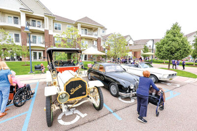  Residents take a stroll past some classic cars on display. 