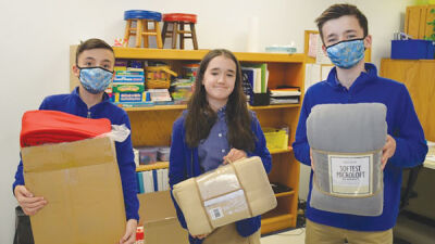  From left, Japhet School students Gabe Shaffer, 13, of Royal Oak; Sloan Hale, 12, of Bloomfield Hills; and Jacob Shaffer, 13, of Royal Oak, stand with fleece blankets their seventh-grade class collected for the Ukrainian-American Response Committee of Michigan. 