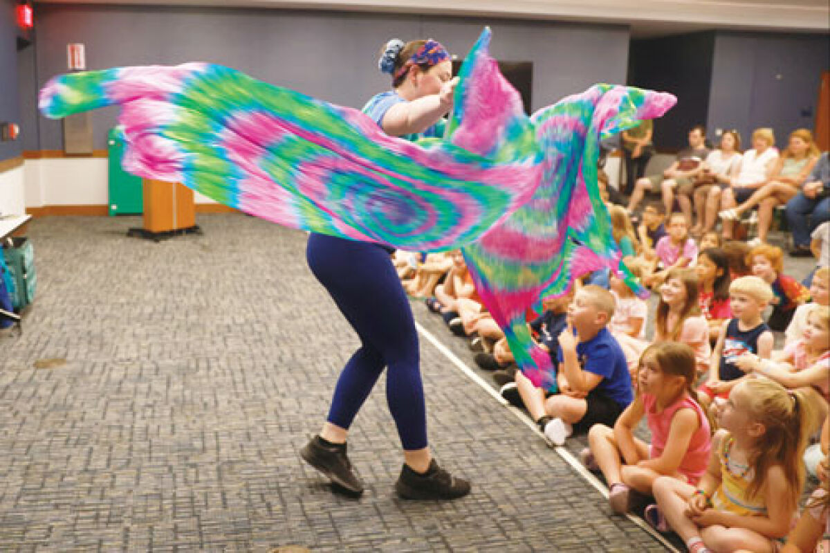  Children are wowed as Kinetic Kay showcases her skills. Her performance included silk fans, poi, and levitation wands.  