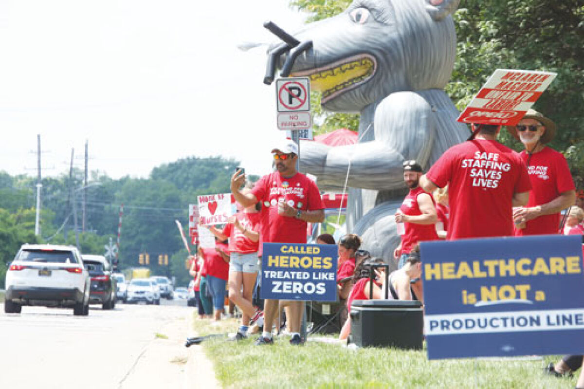  Nurses, support staff and their supporters picket along Harrington Street outside of McLaren Macomb Hospital on June 8.  