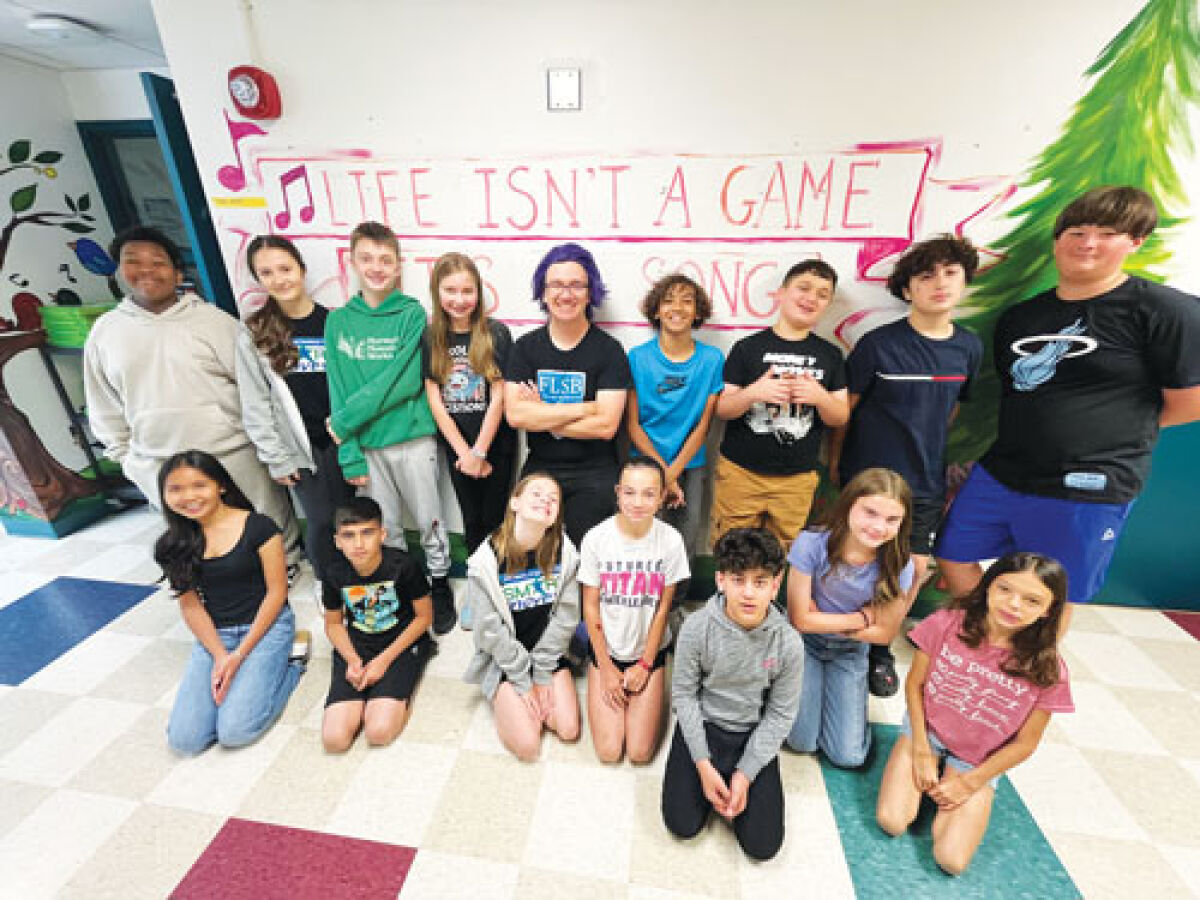 Schuchard Elementary School music teacher Tyler Schreiber poses for a photograph with some of his students.  
