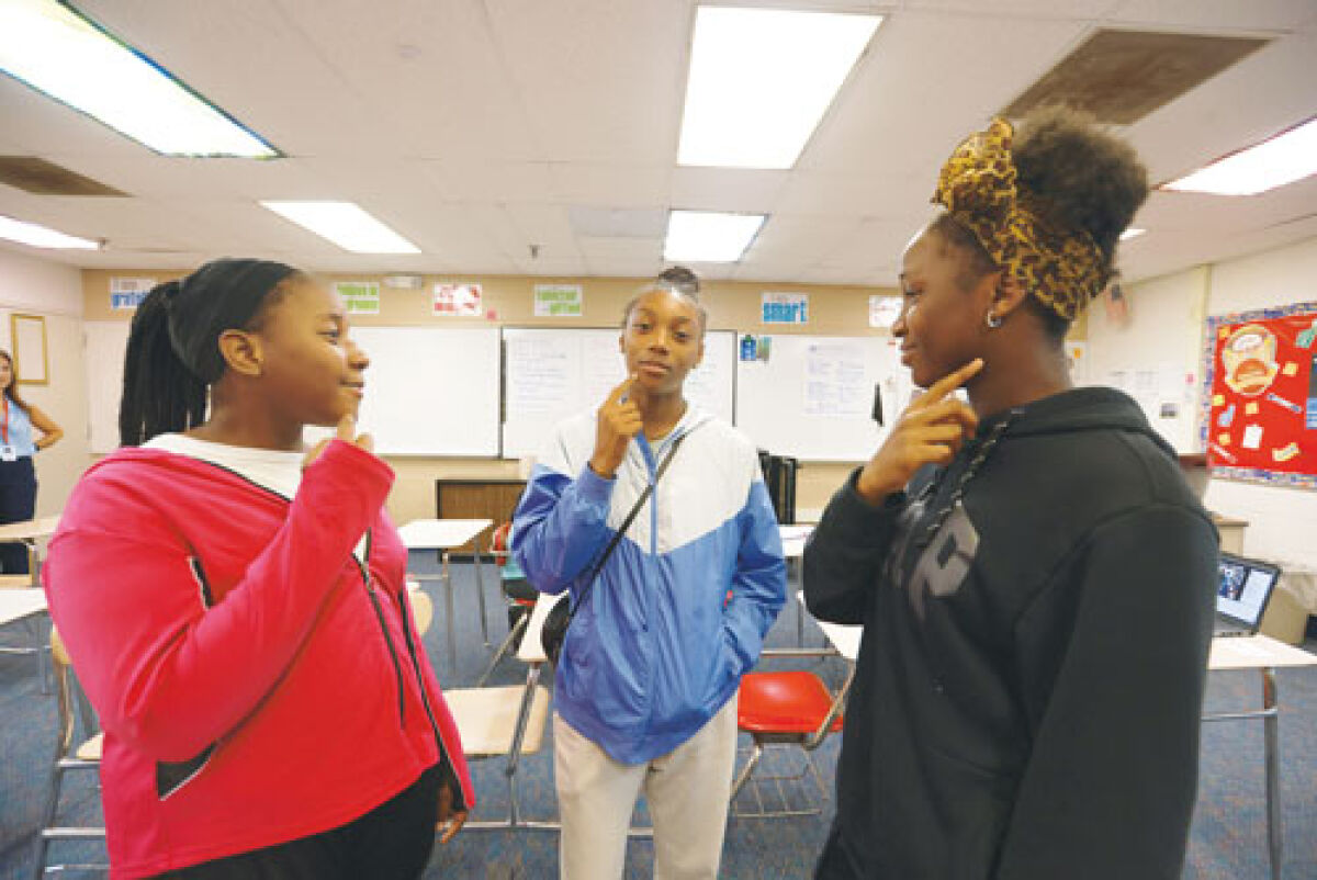  Melanie Brown, 12, and Wynter Thompson and Bineta Amakor, both 13, practice  American Sign Language while in class July 23. 