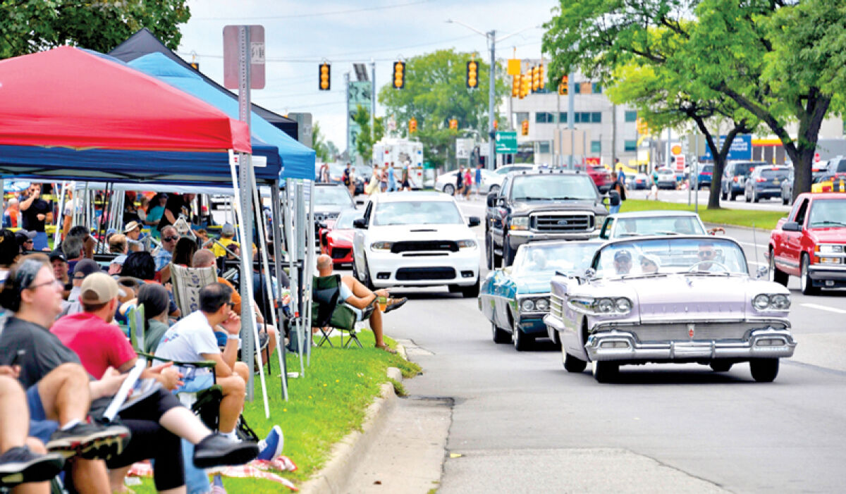  Cars drive down Woodward while spectators watch last year. 