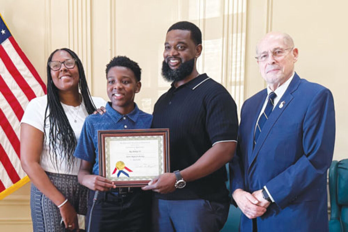  Grosse Pointe Woods student Roy Bishop III is flanked by his parents, Latoya Bishop and Roy Bishop II, as well as Grosse Pointe Woods Mayor Arthur Bryant as the youngest member of the Bishop family is recognized for serving as junior mayor for the day 
