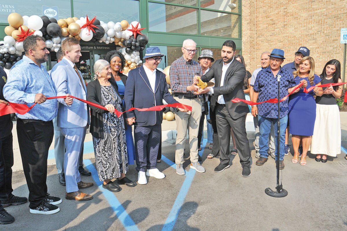  Mayor Ken Siver helps Fifth Avenue Furniture CEO Donovan Zerki cut the ribbon during the store’s grand opening Aug. 2. 