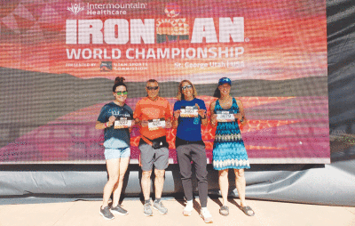  Local athletes stand in front of the Ironman World Championship sign at the 2021 Ironman World Championship. From the left are Jen Hope,  John Reinke, Tara DiLaura and Dominique Rommel. 