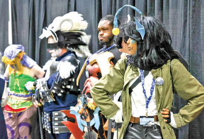  Adults line up to participate in the cosplay contest at the MiAnime Convention Aug. 2. 
