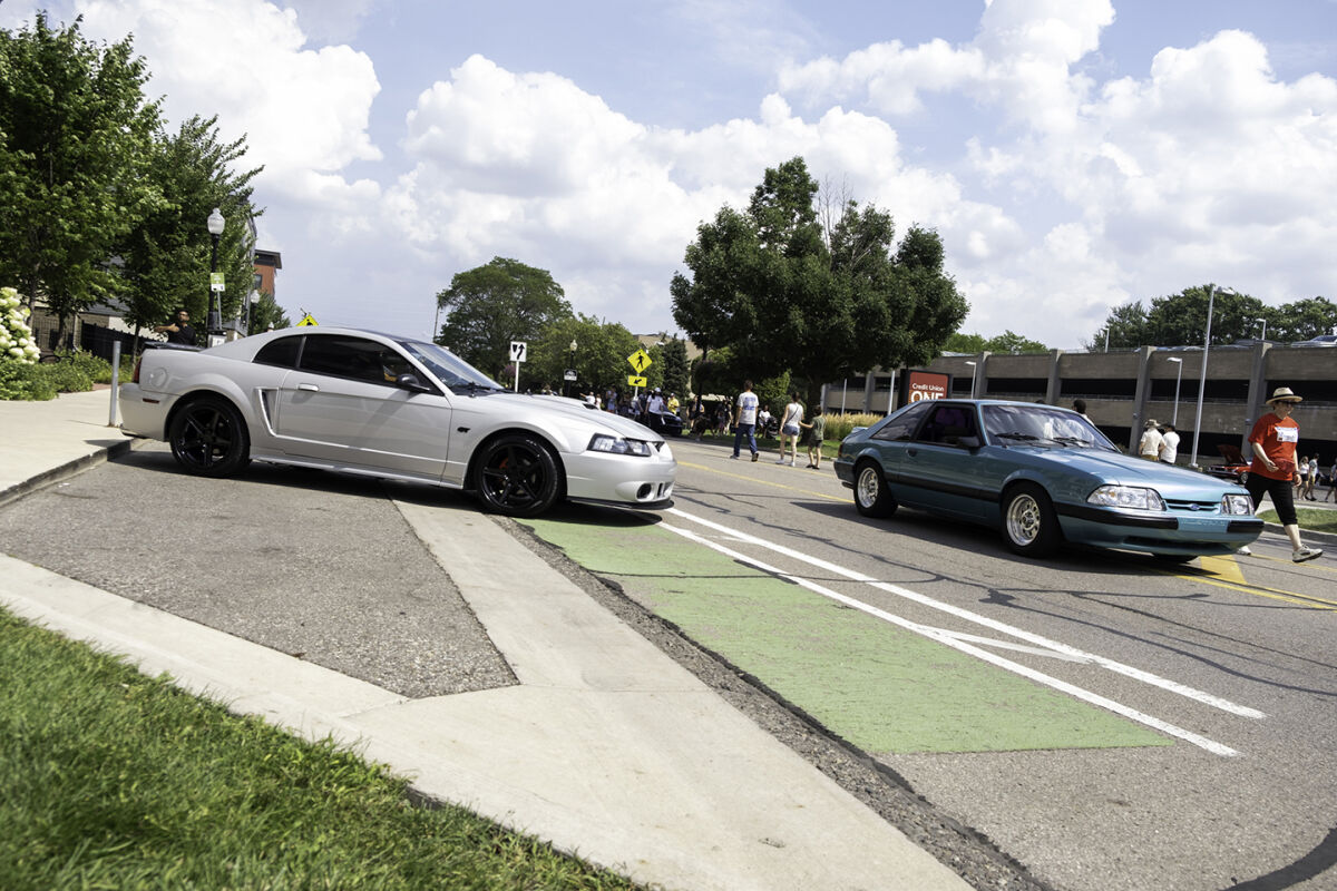  Mustangs are guided into their parking spots in Mustang Alley during the Woodward Dream Cruise Saturday, Aug. 16, 2025, in Ferndale. 