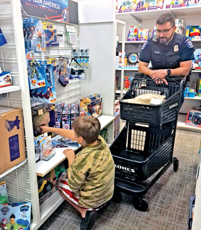  Novi Police Officer Alex Marchione watches as Michael Lewis, 8, picks out a toy. 