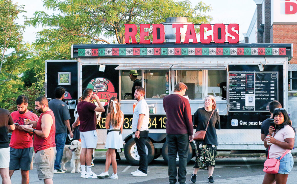 People enjoy food from various taco truck vendors at the 2024 Novi Taco Fest. 