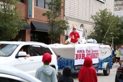  Bob Starkey, the Old Crowd’s 99th “Fish Locator,” sends a salvo of candies to children along North Walnut Street in Mount Clemens on Aug. 21. 