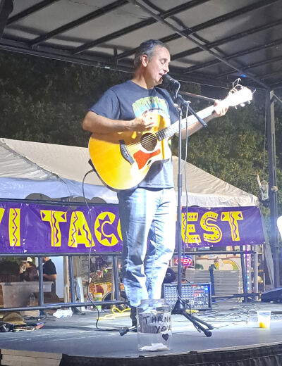  Mark Reitenga, who works for C & G Newspapers, performs at the Novi Taco Fest on Friday night.   