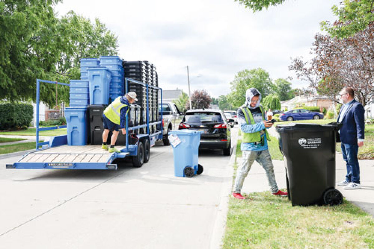  Crews deliver the first batch of trash and recycling carts to homes on Palmer Street Aug. 18. The new carts will be required for curbside pickup in Madison Heights beginning Oct. 6. 