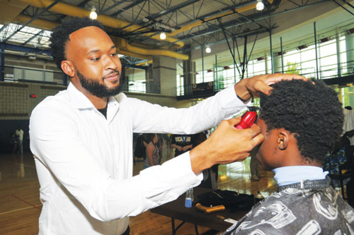  Dason Harold Woods, a 2019 graduate of Fitzgerald High School, brought his barber skills to the Operation Back 2 School event to provide free haircuts for students. The Warren Police Department hosted the event at FHS.  