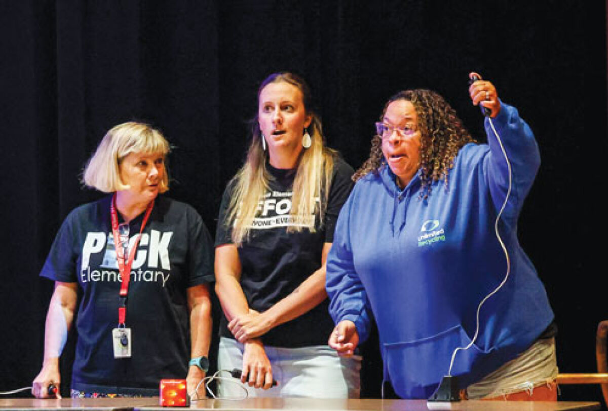  Contestants in the first round — (from left) Team A’s Judy Chapman, Team B’s Angela Oliver, and Team C’s Lanae Kru — look at the clue on the screen before Kruk gave the correct answer.  