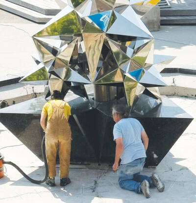  Workers with Venus Bronze Works clean and improve the Star Dream Fountain in Royal Oak. 