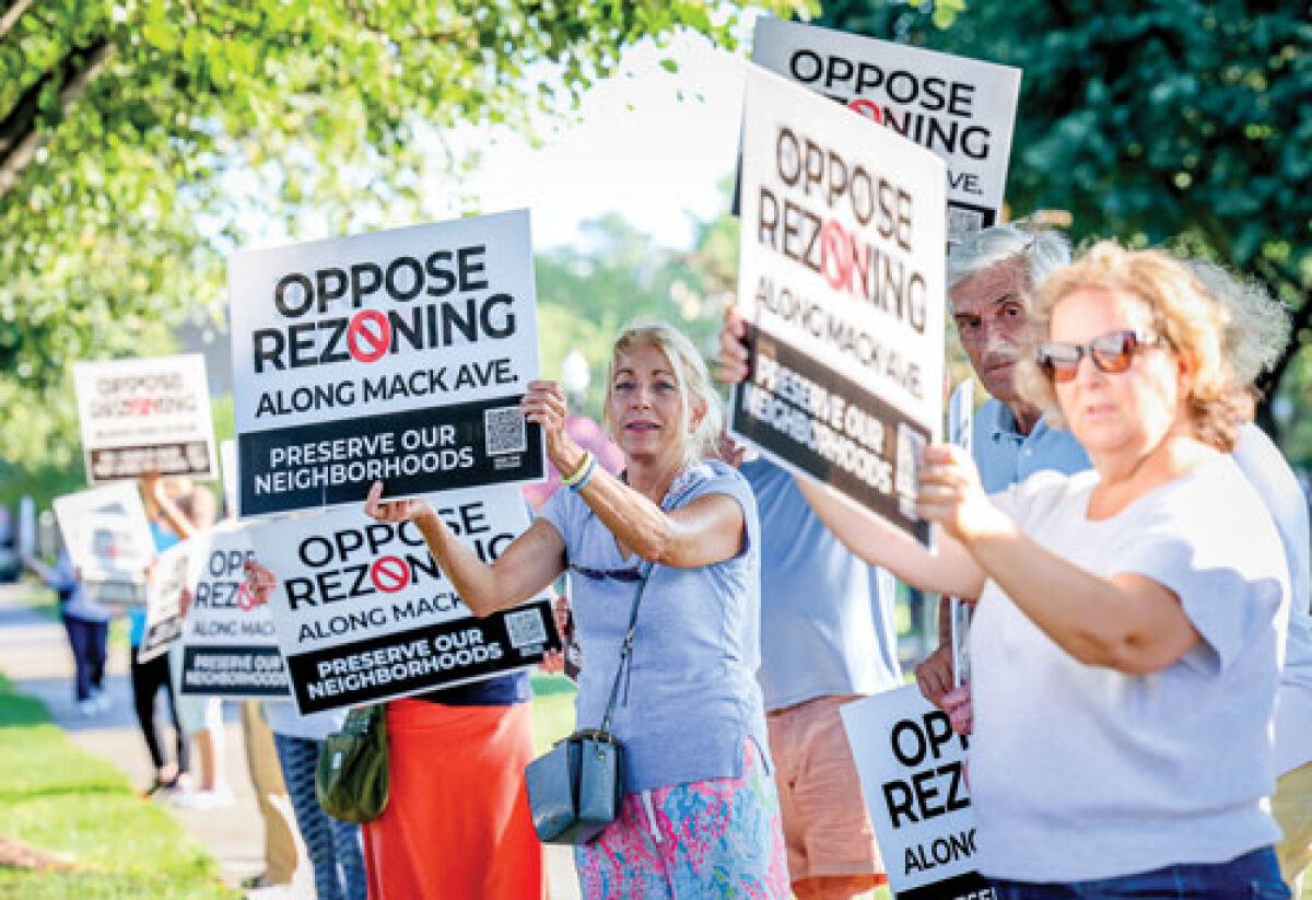  Dozens of residents carry signs to show their opposition to rezoning on Mack Avenue  in Grosse Pointe Woods ahead of an Aug. 18 Woods City Council meeting. 