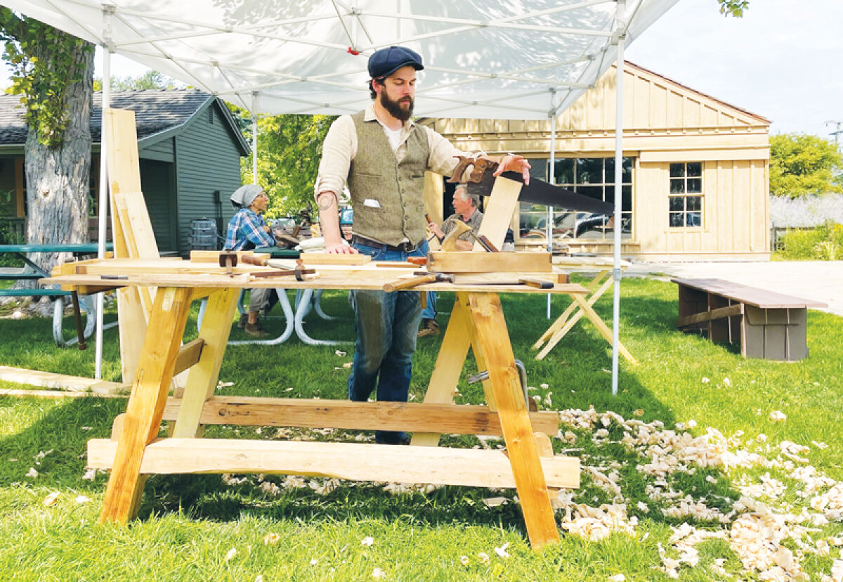  Alex K., the youth programs director for Troy Historic Village, demonstrates his traditional woodworking skills. 
