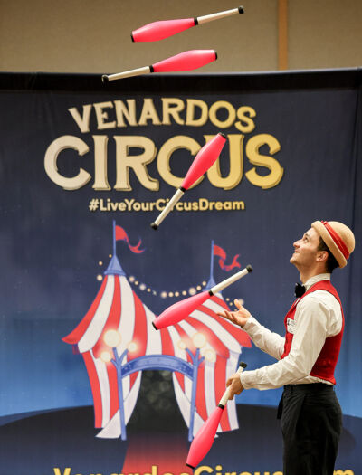  Sam Ferlow, a plain-faced clown, juggles some bowling pins. 