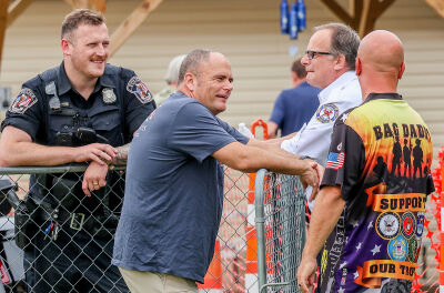  During the event, Roseville Fire Chief Keith Jacobs, second from left, talks with Kris Socha, right. Socha and his fiancée, Wendy Kimmel, of the Warren-based Badges & Bags Cornhole, set up the fundraiser with 10 cornhole boards. 