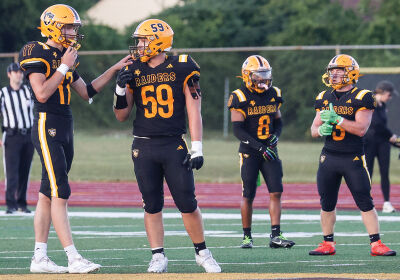  North Farmington players discuss a play before lining up against Livonia Stevenson on Aug. 28. 