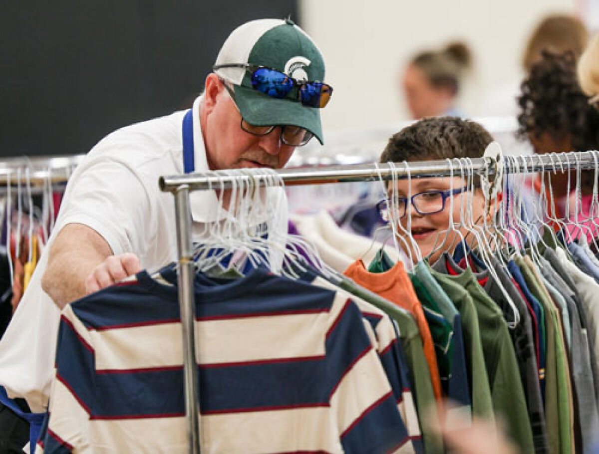  McKinley Elementary School second grader Jaden Douglas, right, shops for shirts with volunteer Steve Green.  