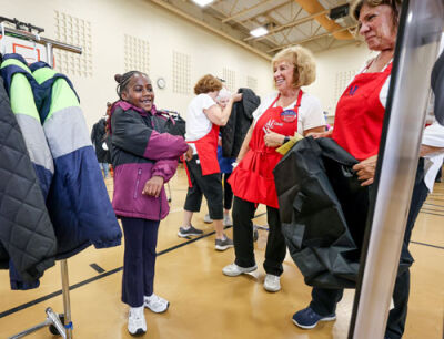  Third grader Harmony Collins delights in her new coat while looking in the mirror.  