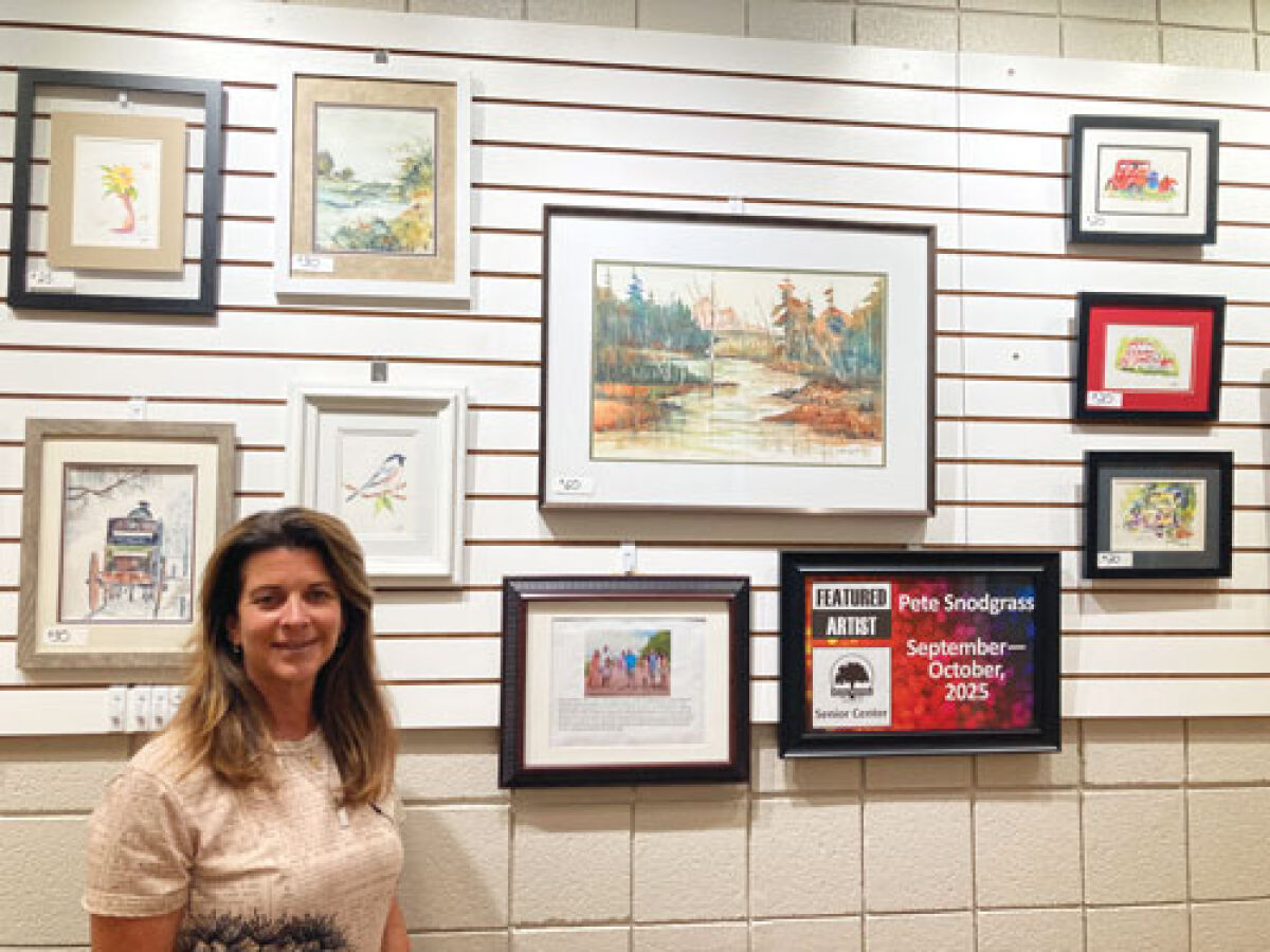  Amy Camilleri, Pete Snodgrass’ daughter, stands in front of her father’s artwork,  which is on display at the Shelby Township Activities Center. 