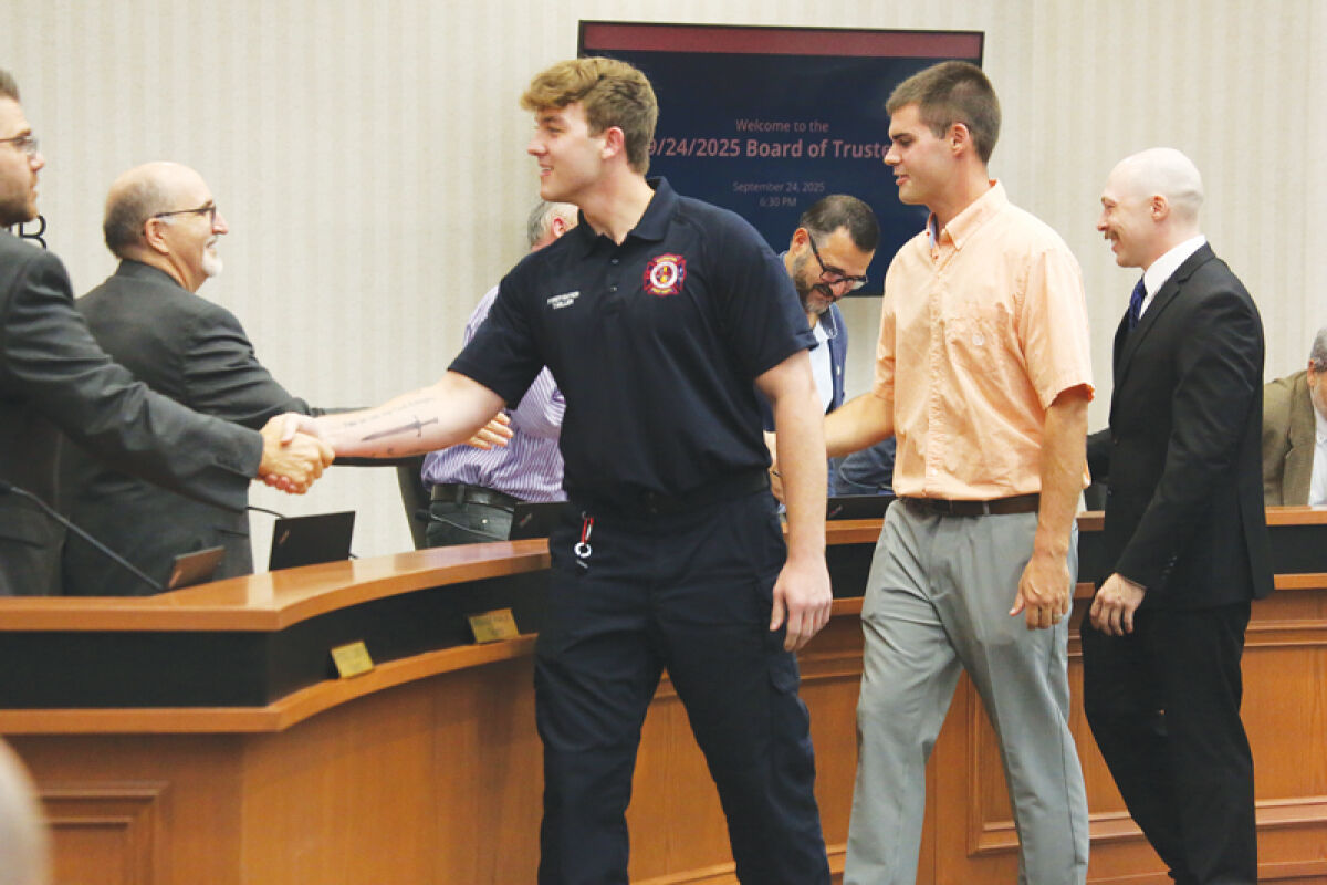  Newly hired full-time firefighters Tyler Miller, middle, Steven Klein and Derek Gapczynski shake hands with members of the Macomb Township Board of Trustees on Sept. 24. 
