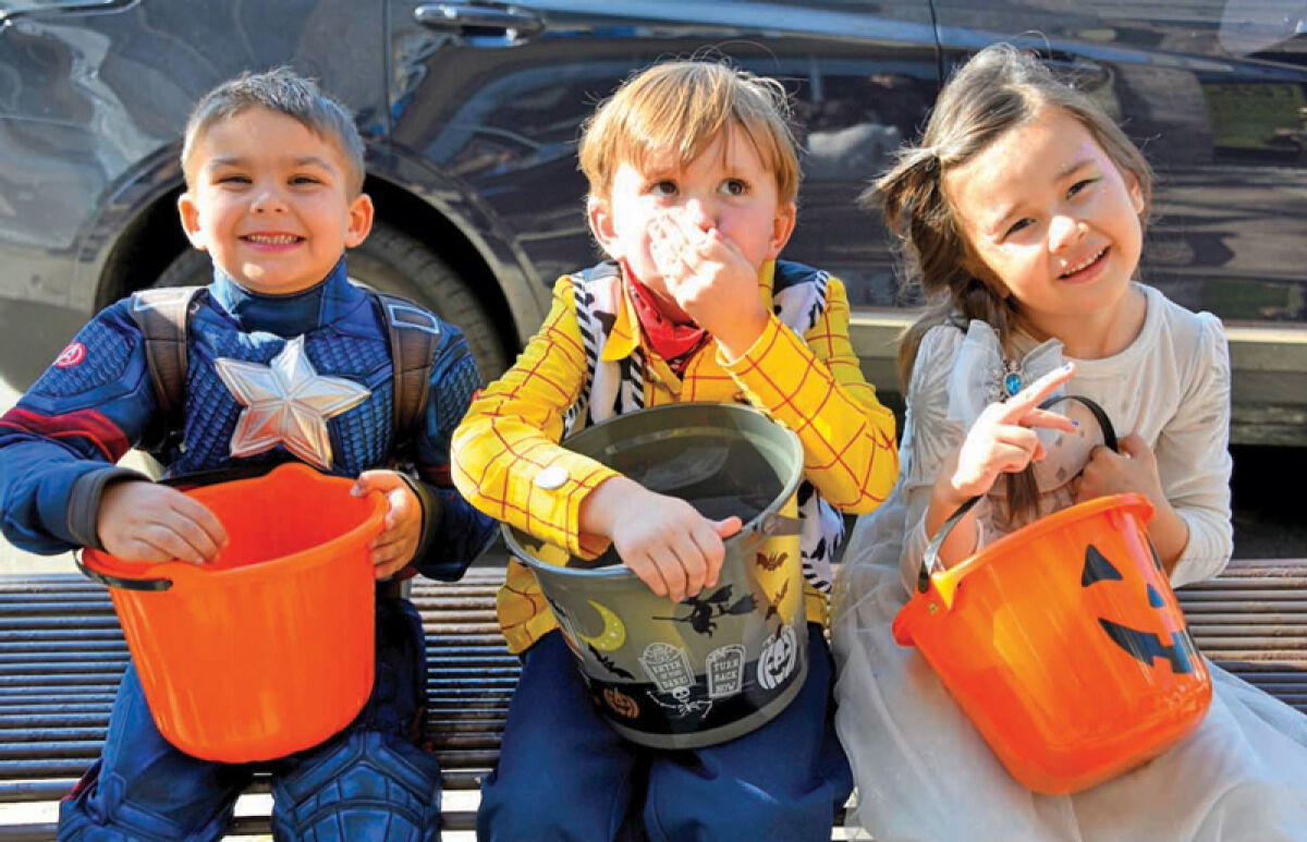 Archer England, 4, of Madison Heights; Rowen Oneill, 4, of Royal Oak; and Athena Kyro, 5, of Madison Heights, enjoy the candy they collected. 