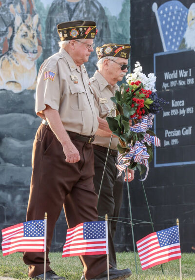  Russ Makowski and Post Cmdr. Mike Longo, of the Veterans of Foreign Wars Post 1519 in Northville place a wreath in front of the POW/MIA memorial. 