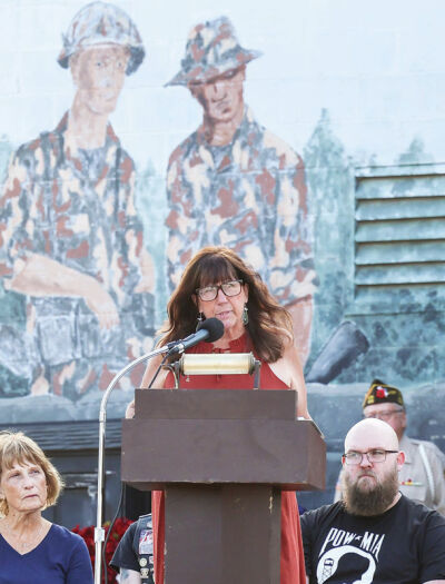  Debbie Pineau McClain, president of the POW Committee of Michigan, speaks to a crowd about the work of the committee to bring those who were prisoners of war and missing in action home. 