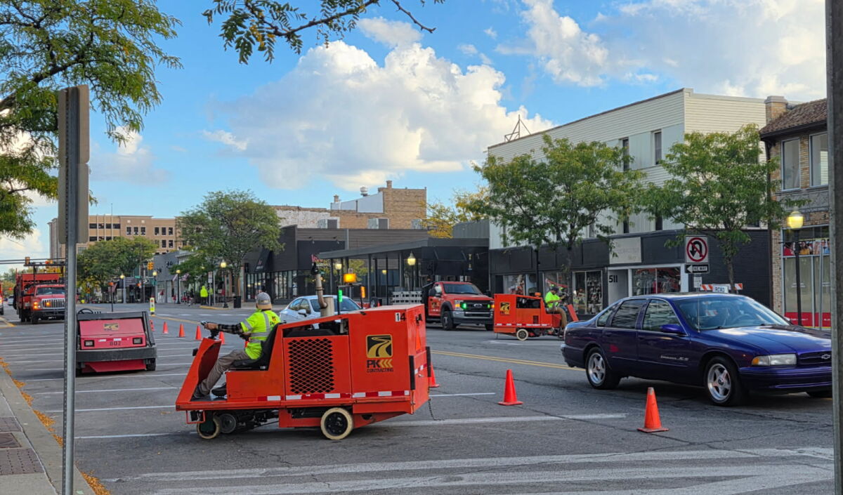  Workers from PK Contracting, of Troy, begin removing the paint from back-in parking spaces Oct. 6 along Washington Avenue in Royal Oak. The lines will be repainted to be traditional pull-in spaces. 