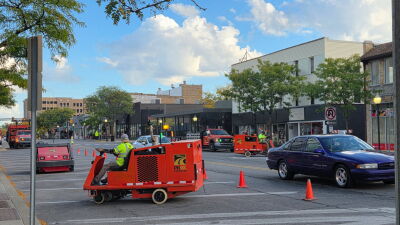  Workers from PK Contracting, of Troy, begin removing the paint from back-in parking spaces Oct. 6 along Washington Avenue in Royal Oak. The lines will be repainted to be traditional pull-in spaces. 