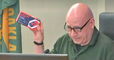  West Bloomfield Board of Trustees member Michael Patton holds up a crank radio as he makes safety recommendations during National Preparedness Month at a special board meeting, Sept. 16. 