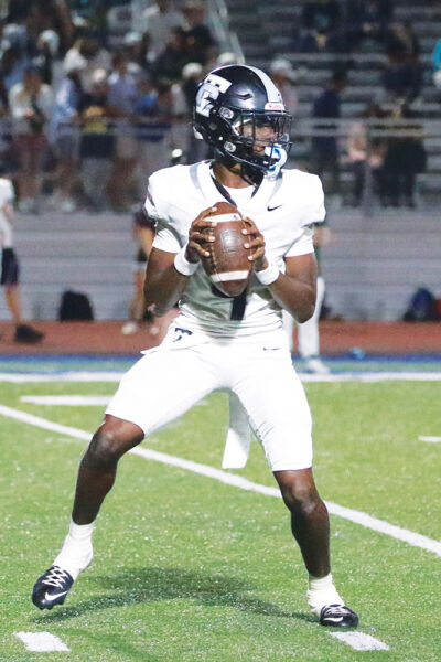  Troy quarterback Darius Mitchell drops back to pass in a game against Farmington Oct. 3. 