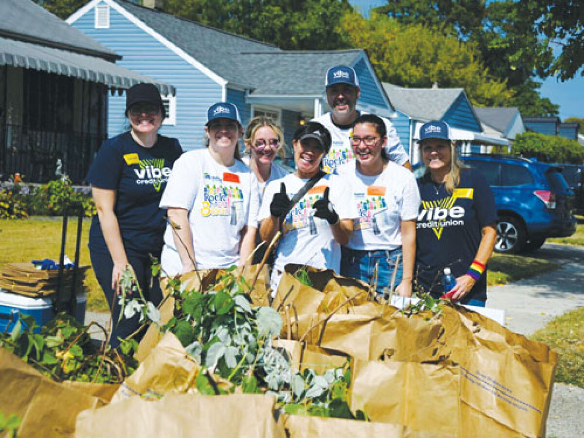  A group of volunteers from Vibe Credit Union proudly display the bags of leaves they filled during the two-day blitz.  