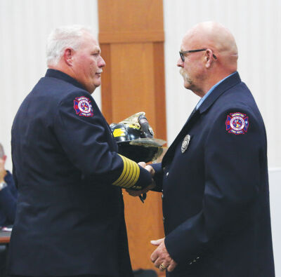  Macomb Township Fire Chief Robert Phillips, left, presents retiring firefighter Steve Anderson with his helmet at the Oct. 8 board of trustees meeting. Anderson served the Macomb Township Fire Department for 28 years in part-time service after serving the Mount Clemens Fire Department as a volunteer for 13 years. 