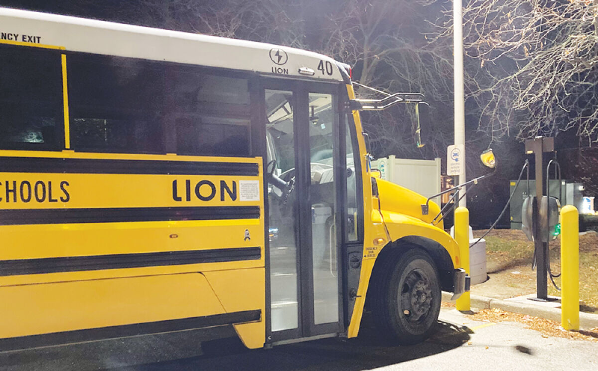  A “clean bus” charges in a store parking lot. More than 20 schools and districts across Michigan have received state funding for new school buses — most of them electric — which will be built this winter. 