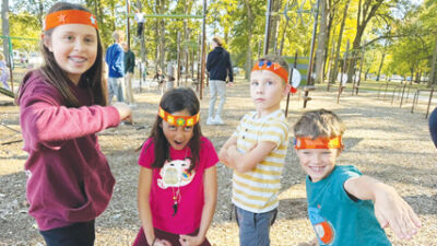  Kids show the headbands they made during the ribbon cutting. 