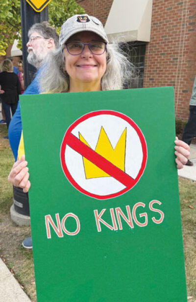 Lori Zurvalec carries a sign with the message of the day.