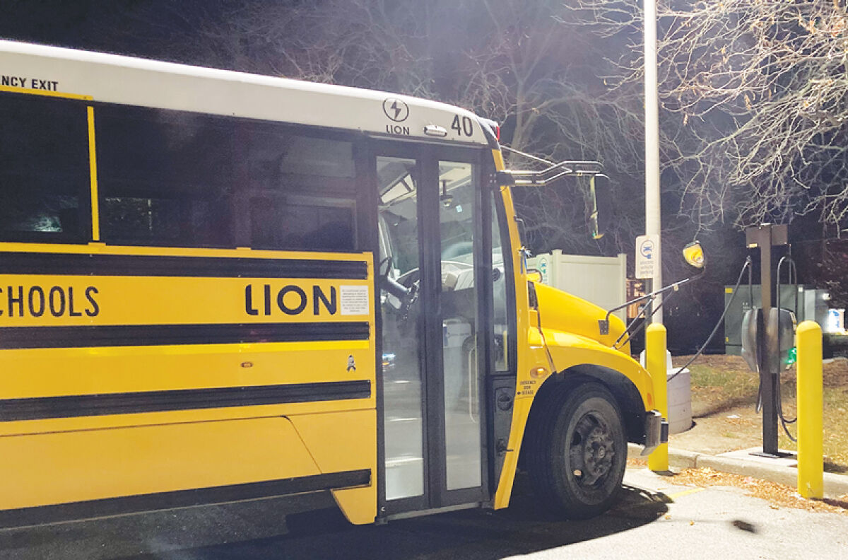  A “clean bus” charges in a store parking lot. More than 20 schools and districts across Michigan have received state funding for new school buses — most of them electric — which will be built this winter. 