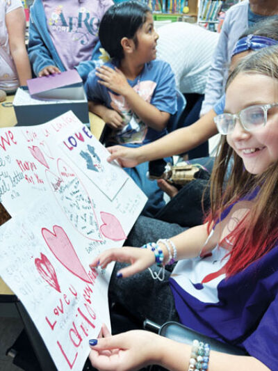  During the Roose Elementary School “Laila Day” Oct. 22, student Laila Breitshtrus reads get well cards classmates made for her as she recovers from her injuries.  