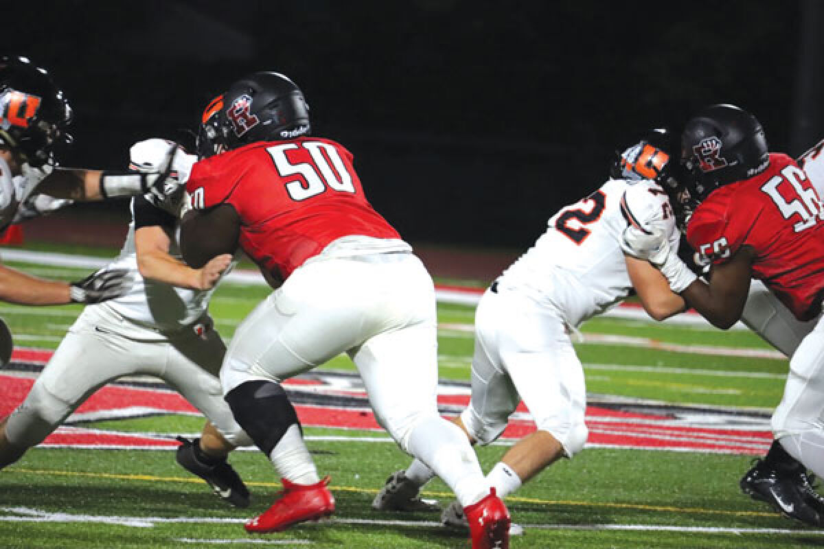  Roseville senior Dezzmon Meriweather (50) and sophomore Michael Chude (56) battle in the trenches against Utica High School on Sept. 30. 