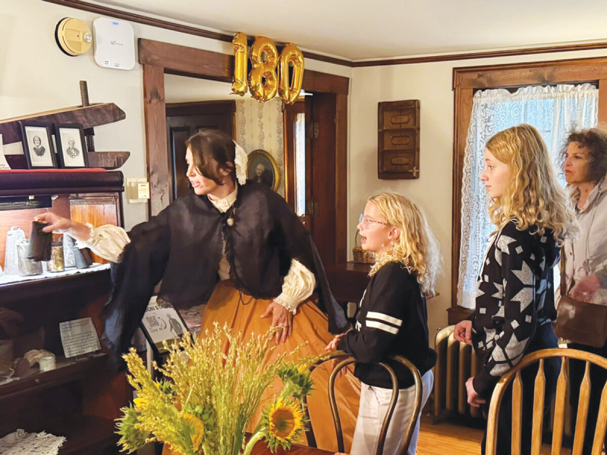  Alex Kerrington gives a tour of the Orson Starr House Oct. 19. The house features a decoration denoting its 180-year anniversary. 