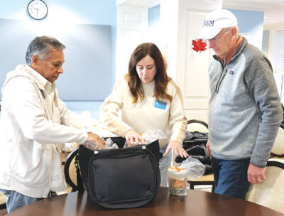  Volunteers at The Helm at the Boll Life Center pack meals that will be delivered to homebound seniors. 