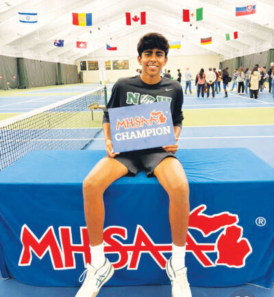  Novi freshman Kris Thomas poses with an MHSAA state champion sign after winning the singles flight 2 event at Midland Tennis Center Oct. 18. 
